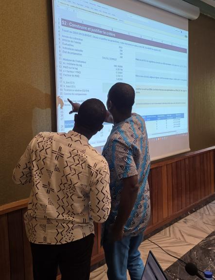 Persons discussing data on screen